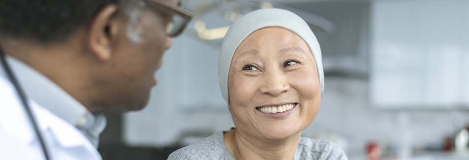 A woman wearing a headscarf smiles at her doctor at Baptist Women’s Health Center